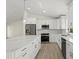 Kitchen features stainless appliances, white cabinets, large island and modern pendant lighting at 7235 Peacock Ln, Englewood, FL 34224