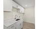 Convenient laundry room with quartz countertops, white cabinets, stainless faucet, and tile floors offers style and functionality at 7235 Peacock Ln, Englewood, FL 34224