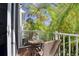 Balcony featuring 2 chairs, a table, and an outdoor view of palm trees at 825 Oak Bend Ln, Dunedin, FL 34698