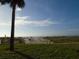 Beautiful beachfront view with a boardwalk, sandy shore, and palm trees at 880 Mandalay Ave # C412, Clearwater Beach, FL 33767
