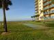 Exterior lawn view of a building with a shuffleboard, greenery and a beach view at 880 Mandalay Ave # C412, Clearwater Beach, FL 33767