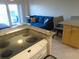 View of a bright living room with a sofa, modern kitchen and outdoor access at 880 Mandalay Ave # C412, Clearwater Beach, FL 33767