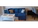 Comfortable living room with a blue sofa, decorative pillows, and coffee table; includes a small wine fridge at 880 Mandalay Ave # C412, Clearwater Beach, FL 33767