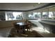 Serene lounge area with a dining table overlooking palm trees and the beach through large windows at 880 Mandalay Ave # C412, Clearwater Beach, FL 33767
