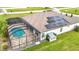 Aerial view of a home featuring solar panels and a screened-in pool area at 9820 Monaghan St, Thonotosassa, FL 33592