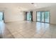 Bright living area with tile flooring, large sliding glass doors, and access to the outdoor patio or pool area at 9820 Monaghan St, Thonotosassa, FL 33592