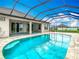 Inviting screened pool surrounded by tile with a spa and lush landscaping in the background at 9820 Monaghan St, Thonotosassa, FL 33592