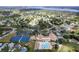 Aerial view of a community with tennis courts, a pool, clubhouse, and surrounding residential area at 2297 Lark E Cir # E, Palm Harbor, FL 34684