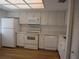 Bright kitchen featuring clean, white appliances, updated countertops, and wood-look flooring at 2297 Lark E Cir # E, Palm Harbor, FL 34684