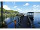Picturesque lake featuring a wooden dock and boat lifts at 2297 Lark E Cir # E, Palm Harbor, FL 34684