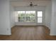 Bright living room with wood-look floors, large windows, and a glass door at 2297 Lark E Cir # E, Palm Harbor, FL 34684