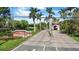 A scenic entrance to Utopia community featuring lush landscaping, palm trees, and a charming gatehouse at 10265 Gandy N Blvd # 1203, St Petersburg, FL 33702