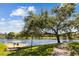 Lake view featuring a large tree and a concrete path along the water's edge, creating a serene outdoor space at 10265 Gandy N Blvd # 1203, St Petersburg, FL 33702