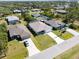 This aerial perspective features three homes, their driveways, and surrounding green space at 109 Beau Rivage Dr, Rotonda West, FL 33947