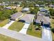 Aerial view of three houses with large driveways and manicured lawns at 109 Beau Rivage Dr, Rotonda West, FL 33947