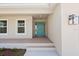 Covered front porch featuring a vibrant blue front door with sidelights and transom window at 109 Beau Rivage Dr, Rotonda West, FL 33947