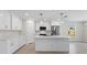 Modern white kitchen with stainless steel appliances and a center island with breakfast bar at 109 Beau Rivage Dr, Rotonda West, FL 33947