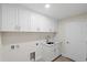 A laundry room has white cabinets, a sink, and a door to the right at 109 Beau Rivage Dr, Rotonda West, FL 33947