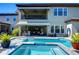 Backyard pool with spa and in-pool loungers, overlooked by a covered outdoor bar and second story patio at 11229 Hawks Fern Dr, Riverview, FL 33569