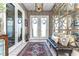 Elegant foyer with ornate mirror decor, tiled floors, a patterned rug and a bench at 11229 Hawks Fern Dr, Riverview, FL 33569