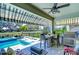 Outdoor kitchen and bar area with a built-in grill next to a pool and hot tub under an awning at 11229 Hawks Fern Dr, Riverview, FL 33569