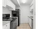 Bright kitchen featuring white cabinets, a smooth cooktop, a black refrigerator, and tiled flooring at 14211 Shadow Moss Ln # 101, Tampa, FL 33613