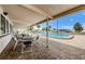 Outdoor patio area with tables and chairs adjacent to the community swimming pool at 159 Melody Ln, Tarpon Springs, FL 34689