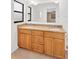 Bathroom featuring dual sinks, a large mirror, wooden cabinetry, and tile flooring at 1710 Orange Hill Way, Brandon, FL 33510