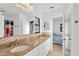Bright bathroom featuring double sinks and a granite countertop, with a view into the bedroom at 1710 Orange Hill Way, Brandon, FL 33510