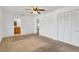 Bedroom featuring neutral carpet, a ceiling fan, a closet, and ensuite bathroom at 1710 Orange Hill Way, Brandon, FL 33510