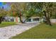 Inviting home with a long driveway and a well-manicured lawn, surrounded by mature trees at 1710 Orange Hill Way, Brandon, FL 33510
