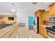 Kitchen with breakfast bar, granite counters, stainless appliances and oak cabinets open to the living area at 1710 Orange Hill Way, Brandon, FL 33510