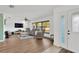 Open-concept living room with lots of light from a large window, showcasing hardwood floors and neutral furnishings at 1710 Orange Hill Way, Brandon, FL 33510