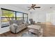Bright living room with wood floors, a ceiling fan, large window, and comfortable seating at 1710 Orange Hill Way, Brandon, FL 33510