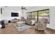Bright living room with hardwood floors, a large window, and comfortable seating area with neutral tones at 1710 Orange Hill Way, Brandon, FL 33510