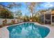 Sparkling in-ground pool with a screened lanai, surrounded by a white fence and lush greenery at 1710 Orange Hill Way, Brandon, FL 33510