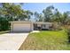 Charming single-story home featuring an attached two-car garage, brick accents, and well-maintained landscaping at 1751 Sutton Pl, Dunedin, FL 34698