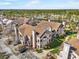 Aerial view of townhomes with tile roofs surrounded by lush landscaping and trees at 17978 Villa Creek Dr, Tampa, FL 33647
