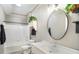 Bright bathroom with a white vanity, oval mirror, and a shower-tub combination at 17978 Villa Creek Dr, Tampa, FL 33647