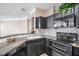Modern kitchen with black cabinets, stainless steel appliances, and a unique backsplash design at 17978 Villa Creek Dr, Tampa, FL 33647