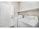 Cozy laundry room includes modern washer and dryer with shelving at 17978 Villa Creek Dr, Tampa, FL 33647