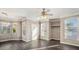 Open-concept living room with hardwood floors, large windows, and a ceiling fan at 17978 Villa Creek Dr, Tampa, FL 33647