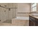 Bathroom featuring a glass shower, soaking tub, and neutral tile at 2081 Backwater Trl, Palm Harbor, FL 34685