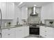 Modern kitchen featuring white cabinets, granite countertops, stainless steel appliances, and tiled backsplash at 222 11Th N Ave, St Petersburg, FL 33701