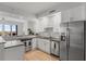 Modern kitchen with stainless steel appliances, light wood floors, white cabinets, and stone countertops at 226 5Th N Ave # 901, St Petersburg, FL 33701