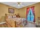 Cozy bedroom featuring a metal frame bed, floral bedding, and a bright window at 25 Windrush Bay Dr # 25, Tarpon Springs, FL 34689