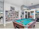 Recreation room with a pool table, built-in bookshelves, and sliding glass doors to an outdoor patio at 25 Windrush Bay Dr # 25, Tarpon Springs, FL 34689