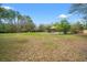 Expansive backyard with mature trees and the home in the distance at 27930 Ravens Brook Rd, Wesley Chapel, FL 33544