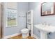 Cozy bathroom featuring a stylish vanity with white basin sink, a window, and a shower with glass doors at 27930 Ravens Brook Rd, Wesley Chapel, FL 33544