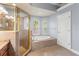 Primary bath featuring granite countertops, soaking tub, and large glass enclosed shower at 27930 Ravens Brook Rd, Wesley Chapel, FL 33544